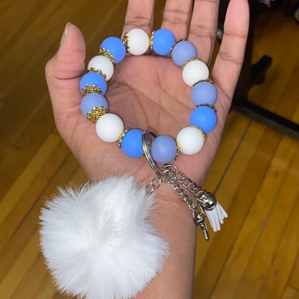 Blue and white bracelet keychain with white pom-pom
